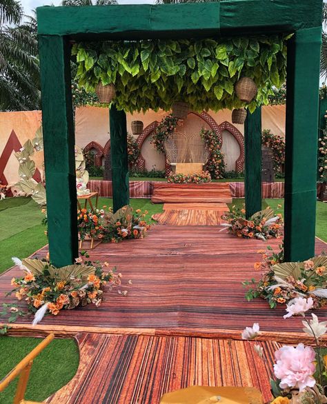 Emerald green mandap with foliage canopy and floral aisle
